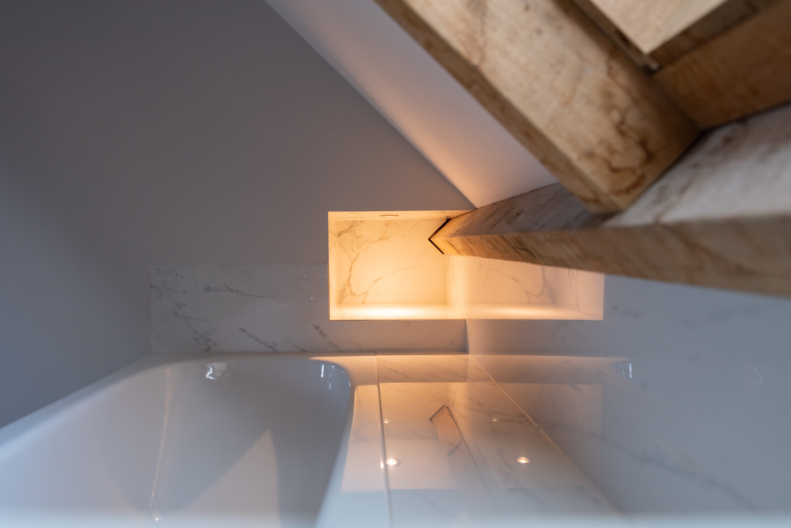 Bad onder een schuine dak met marmeren tegels